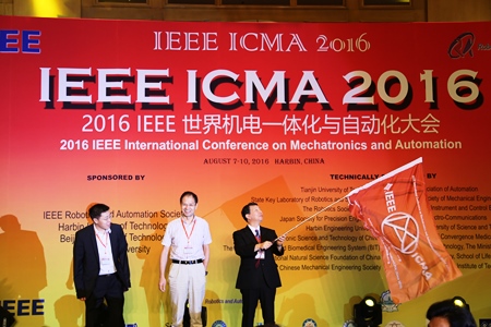 香川大学が IEEE ICMA 2017 開催をアピールする様子（右：平田英之教授）