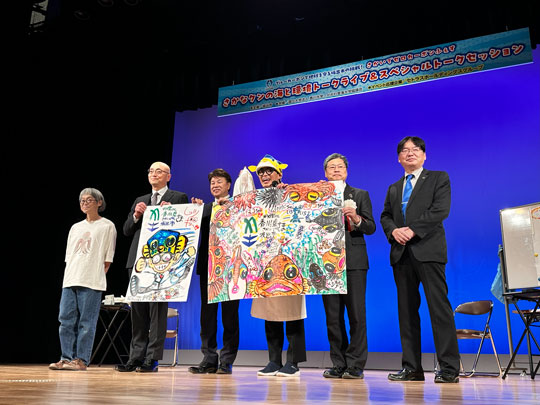 ①ステージでの記念撮影(左から:山口氏、木下社長、有福坂出市長、さかなクン、上田学長、末永副学長)-1.jpg