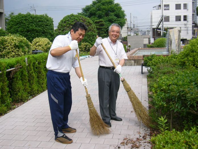 構内清掃を行う一井学長（右）