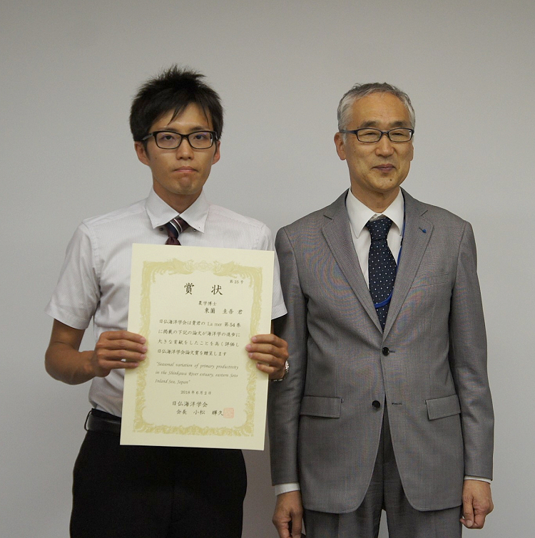 授賞式にて賞状を手にする東薗博士（左）。右は小松学会長